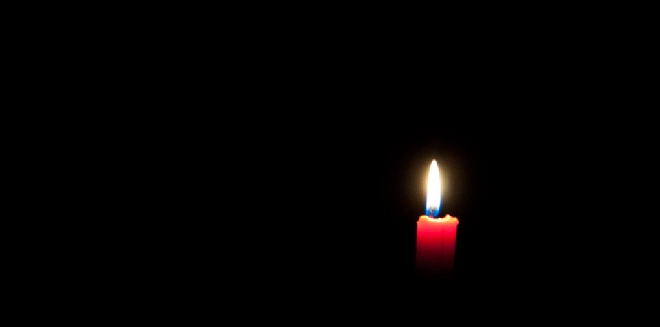 lit-candle-in-a-black-room.webp