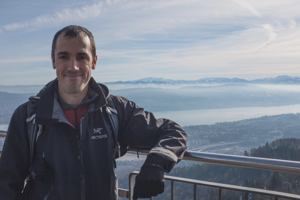 man-standing-in-front-of-swiss-mountains-at-uetliberg-zurich.webp