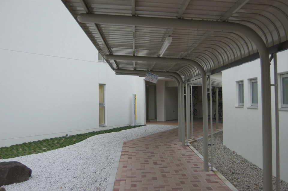 La puerta del edificio oeste donde estoy alojado. El hueco que se ve a la derecha es un pequeño parking de bicis.