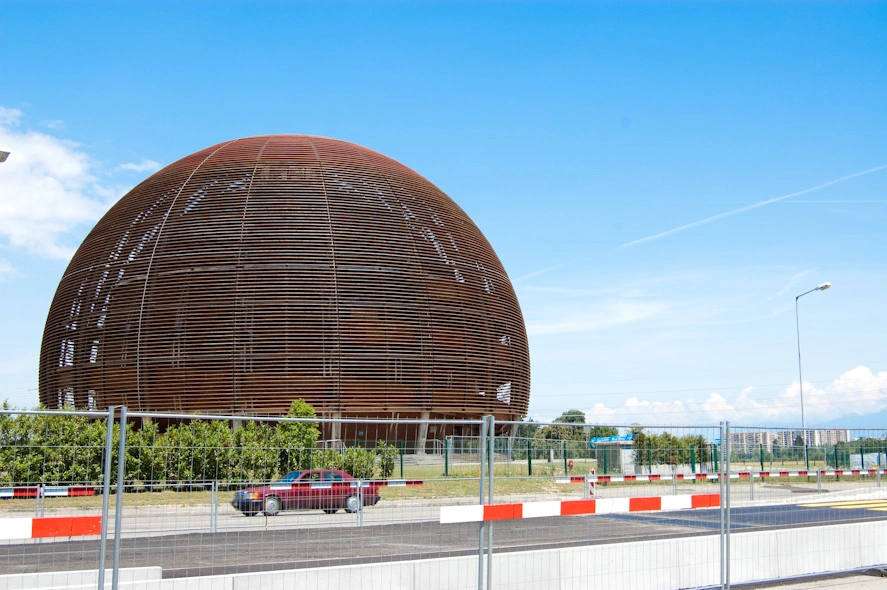 El Globo. Este edificio se utiliza como centro de exposiciones (la primera planta) y como auditorio temporal (la segunda planta). Por ejemplo esta semana el auditorio principal estaba ocupado por unas charlas así que las clases que nos dan a los que participamos en el programa de estudiantes de verano se han impartido en la segunda planta de este globo de madera. Cuando llegué, hace ya dos semanas, había una exposición sobre Ángeles y Demonios y hoy, en una de las clases que tenía que era sobre antimateria, el profesor que la impartía no se cortó a la hora de hacer bromas con la película; un compinche llegó en medio de la charla con un aparato que supuestamente contenía un gramo de antimateria como el que se utilizó en la película (una especie de tubo transparente alargado con algo brillante en el centro).