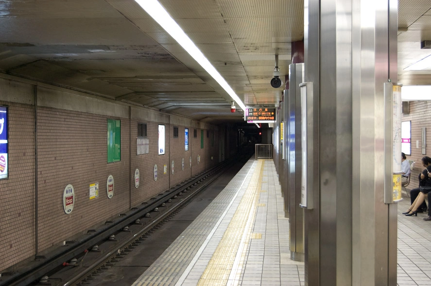  Al contrario que en España los trenes circulan generalmente por el exterior y la gente por el interior. Si te equivocas de anden solo tienes que dar unos pasos, sin correr por las escaleras. La línea amarilla para los invidentes está presente también aquí. En el suelo están indicados los puntos donde se abren las puertas de los vagones y la gente ¡hace colas de forma organizada enfrente de dichos puntos! Por cierto, quien haya visto Gantz es probable que la foto le resulte familiar.