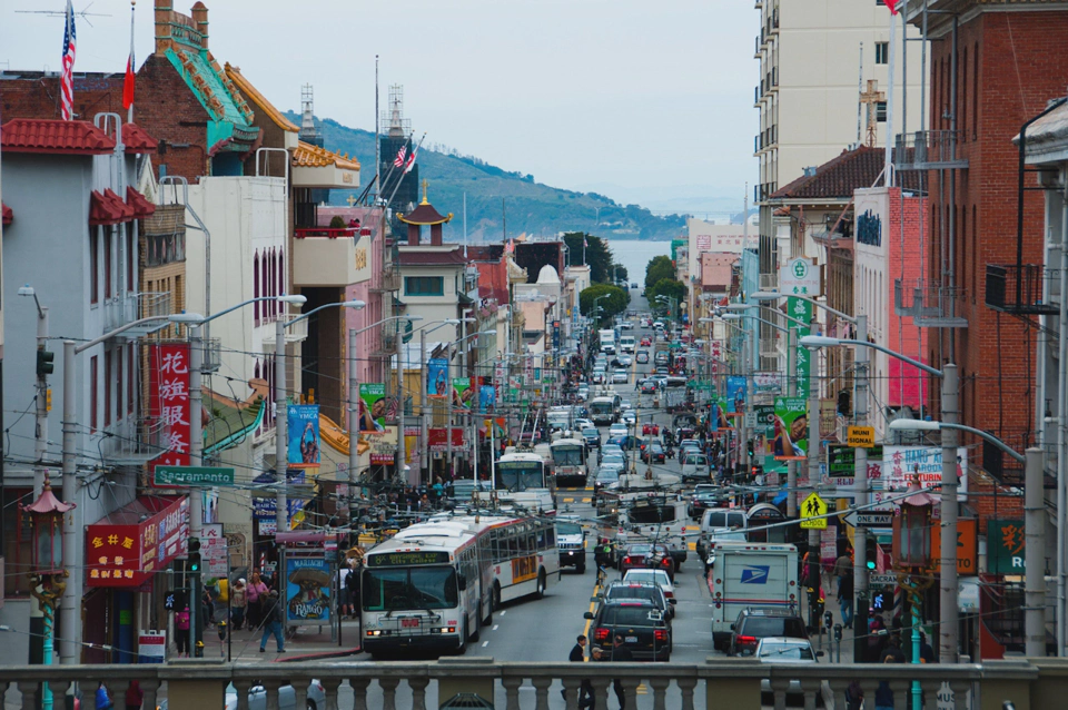 An American style red brick building on the right, a hill at the back, Spanish themed street names, Chinese shops, Indian traffic, Japanese visual pollution.