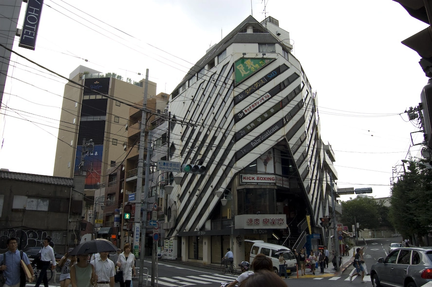 Un gimnasio de kickboxing, un edificio zebra, unas pintadas en la acera de enfrente, una azotea bordeada de árboles en el edificio izquierdo y una calle solitaria a la derecha. Mi intención era sacar una foto de una zona de Shibuya que no fuera interesante pero es que si empiezo a fijarme..